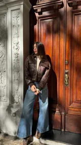 Campera de cuero marrón estilo bomber, con cuello camisero, bolsillos frontales con solapa y puños de tejido elástico.