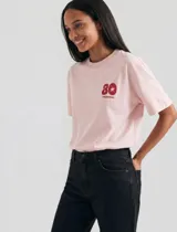 Remera rosada de manga corta con cuello redondo y estampa frontal pequeña de Hering con el número 80 y una estrella.
