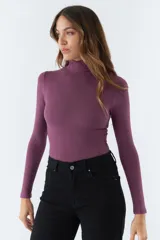 Polera negra de cuello alto y manga larga, de corte ajustado.