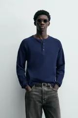 Camiseta de manga larga con cuello redondo y cierre frontal de botonadura tipo henley, confeccionada en tejido de punto con textura waffle.