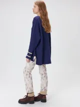 Sweater de punto con diseño de rombos en relieve, cuello redondo y calce holgado. Presenta aberturas laterales en el ruedo y logo bordado en el pecho.