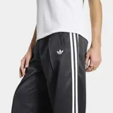 Pantalón deportivo Adidas Satin Loose de corte holgado, color negro con las icónicas tres tiras blancas a los lados y el logo del trifolio bordado. Confeccionado en tejido satinado con diseño de perneras anchas.