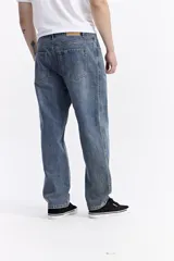 Jean baggy de hombre, color azul claro, con tiro medio, corte amplio en piernas y cadera, y pasacinto.