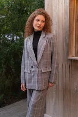 Blazer cruzado de viscosa con estampado de cuadros en tonos grises, blancos y rojos, solapas de muesca, bolsillos con solapa y cierre de botones delanteros.