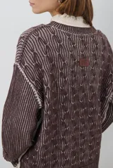 Buzo reversible de tejido de punto con diseño de trenzas, cuello redondo y mangas largas. Presenta una combinación de colores en contraste, con un lado en violeta y el otro en marrón oscuro.