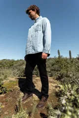 Camisa de jean celeste, de corte clásico, con cuello abotonado, manga larga y bolsillo en el pecho.