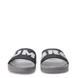 Chanclas tipo slide Umbro, con banda ancha negra y logo en relieve blanco. Presentan una plantilla anatómica y suela de EVA gris con textura antideslizante.