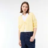 Chaqueta de punto con textura de croché en color amarillo pastel, con diseño de cuello en V, cierre frontal con lazada y terminaciones festoneadas en mangas y ruedo.