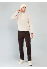 Sweater de punto en color beige, con cuello alto y cierre frontal parcial. Diseño de manga larga con puños y ruedo acanalados.