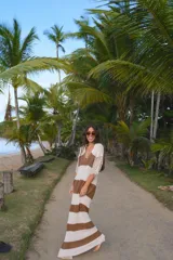 Vestido largo de tejido de punto con rayas horizontales en blanco y marrón. Presenta cuello polo y mangas tres cuartos con tejido de red calado.