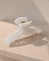 Pinza de pelo amplia con diseño marmolado en tonos blancos y grises, con resorte metálico dorado.