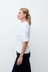 Remera blanca de manga tres cuartos con detalles de bordado calado en el frente y en los hombros, con cuello redondo y puños elásticos.