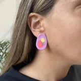 Par de aros con forma ovalada irregular, color verde lima con detalles en rosa y aplique de strass.