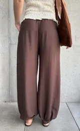 Pantalón de corte babucha color chocolate, de diseño holgado con cintura elástica fruncida y cordón ajustable.
