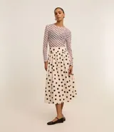 Pollera midi evasé de tricolina color beige con lunares negros, cintura ancha con elástico en la espalda y algodón certificado BCI.