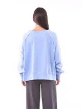 Buzo celeste de corte holgado con escote en V y mangas largas.