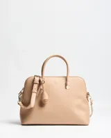 Cartera Flavia color beige de símil cuero con textura granulada, doble asa de mano y correa larga ajustable y desmontable. Cuenta con cierre superior y detalles de herrajes dorados.