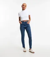 Pantalón mom jeans con bolsillos y bajo plegado, confeccionado en tejido denim azul. Tiene trabillas en la cintura y cierre con botón y cremallera.