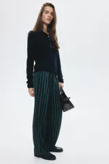 Pantalón de mujer a rayas verticales azul marino y verde, con cintura elástica, bolsillos laterales discretos y bolsillos traseros decorativos. Presenta piernas rectas con pliegues delanteros y traseros.