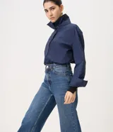 Pantalón wide leg de tiro alto confeccionado en jean de algodón, con pretina con pasacintos, cierre frontal con botón y cremallera, y bolsillos delanteros y traseros.