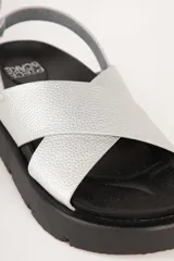 Sandalias negras de tiras cruzadas en símil cuero, con plataforma de 4cm de alto y tira ajustable con hebilla metálica.