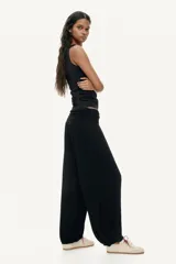 Pantalón de corte holgado en punto de viscosa, de color negro, con cintura elástica ancha fruncida y piernas estilo globo con puños elásticos en los tobillos.
