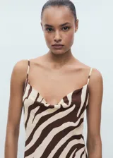 Vestido midi de viscosa con estampado de cebra en tonos marrón y beige. Presenta un diseño recto con cuello drapeado y tirantes finos ajustables.