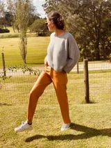 Pantalón de cuero ovino color camel, corte mom fit con tiro semi alto y tajos inferiores.