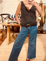 Cinto de cuero negro con hebilla metálica plateada y tachas plateadas.