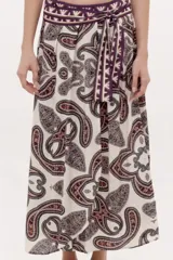 Falda larga fluida de diseño envolvente con estampado paisley en tonos bordó, negro y blanco, con cintura alta decorada con cenefa geométrica y lazo lateral.
