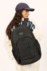 Mochila Billabong Roadie color negro, con múltiples compartimentos con cierre y parche con el logo de la marca en el frente.