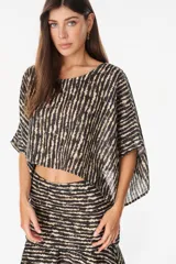 Blusa cropped de lino italiano con diseño holgado, mangas cortas amplias, escote redondo y estampado de rayas verticales degradadas en tonos negro y beige.