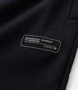 Pantalón deportivo de corte slim para hombre, confeccionado en poliéster color negro. Presenta cintura elástica con cordón de ajuste, bolsillos laterales y diseño ajustado en muslos y rodillas.