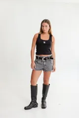 Cinto negro de cuero con hebilla plateada estilo western y apliques de tachas plateadas.