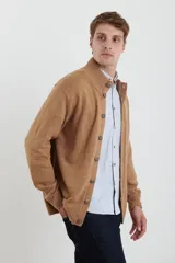 Cardigan de tejido de punto color azul piedra melange, con cuello mao y cierre frontal de botones.