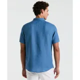 Camisa celeste de lino con manga corta, cuello abotonado y bolsillo en el pecho.