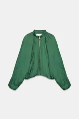 Cazadora satinada verde con cuello redondo fruncido y cierre frontal de cremallera metálica dorada. Presenta mangas largas abullonadas y diseño holgado.