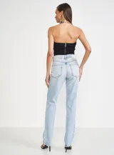 Pantalón de jean celeste con roturas en las rodillas, tiro alto y corte recto.