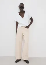 Camiseta blanca de algodón con cuello en V y mangas cortas de diseño holgado.