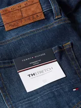 Jeans de corte recto confeccionados en tejido denim de algodón elástico azul oscuro. Presenta el parche con el logo de Tommy Hilfiger en la parte trasera.