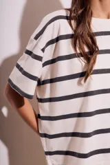 Remera de algodón color crudo con rayas horizontales negras, corte holgado y mangas cortas.