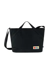 Bolso bandolera negro de la marca Fjallraven, modelo Vardag Crossbody, con logo rectangular de la marca en el frente y etiqueta con la bandera sueca en el lateral.