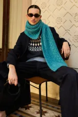 Bufanda de tejido de punto con diseño de trenzas, color turquesa, con textura suave y voluminosa.