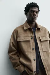 Sobrecamisa regular fit color verde oscuro, confeccionada en tejido efecto ante. Cuenta con cuello solapa, manga larga con puño abotonado, bolsillos de plastrón con solapa en el pecho y bolsillos de vivo en la cadera. El cierre es frontal con botonadura.