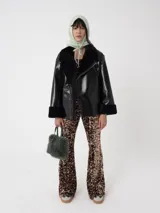 Campera oversized de cuero sintético negro con interior de piel sintética al tono, solapas amplias, cierre frontal y puños con detalle de piel.