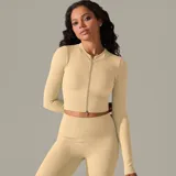 Campera deportiva color beige, de tejido acanalado, corte ajustado y cierre frontal.