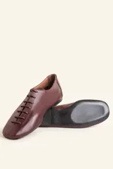 Zapatos chatos de cuero color bordó, con cordones finos y punta cuadrada.