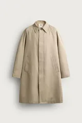 Trench relaxed fit de algodón color beige, con cuello solapa, manga larga y cierre frontal de botonadura oculta por solapa. Presenta bolsillos de vivo en la cadera y abertura en el centro de la espalda.