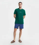 Remera de corte comfort color verde, con cuello redondo y manga corta. Presenta un pequeño estampado minimalista en el centro del pecho con la inscripción 'Nautique des Regates'.