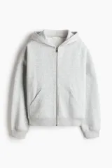 Campera canguro de felpa color gris melange, de corte holgado con interior cepillado suave. Cuenta con hombros caídos, capucha forrada, cierre frontal y bolsillos delanteros abiertos, con puños y bajo en punto acanalado.